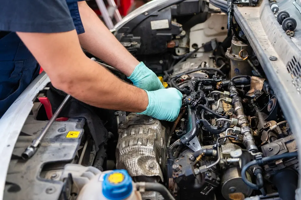 Technician in green gloves performing Bosch diesel service repairs